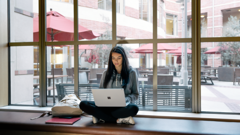 woman working on her laptop by the window